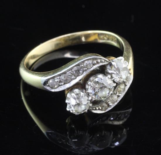 An 18ct gold three stone diamond ring in a diamond twist setting, size M.